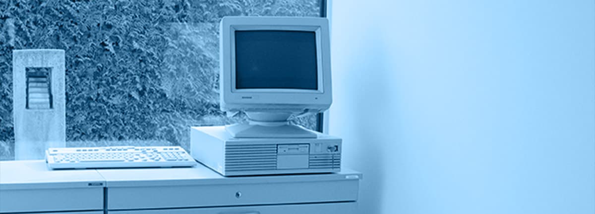 Alter Computer mit Röhrenmonitor auf einem Büroschrank